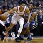 Back from injury, Phoenix Suns guard Devin Booker (1) dribbles past Memphis Grizzlies guard Andrew Harrison, right, during the first half of an NBA basketball game, Tuesday, Dec. 26, 2017, in Phoenix. (AP Photo/Ross D. Franklin)