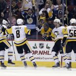Pittsburgh Penguins right wing Carter Rowney (37) celebrates with Bryan Rust (17), Brian Dumoulin (8), and Kris Letang (58) after scoring a goal in the second period during an NHL hockey game against the Arizona Coyotes, Saturday, Dec 16, 2017, in Glendale, Ariz. (AP Photo/Rick Scuteri)