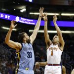 Back from injury, Phoenix Suns guard Devin Booker (1) shoots over Memphis Grizzlies center Marc Gasol (33) during the first half of an NBA basketball game, Tuesday, Dec. 26, 2017, in Phoenix. (AP Photo/Ross D. Franklin)