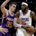 Phoenix Suns forward Dragan Bender, left, fouls Los Angeles Clippers center Willie Reed during the second half of an NBA basketball game in Los Angeles, Wednesday, Dec. 20, 2017. The Clippers won 108-95. (AP Photo/Chris Carlson)