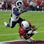 Arizona Cardinals wide receiver Larry Fitzgerald (11) scores a touchdown as Los Angeles Rams free safety Lamarcus Joyner (20) defends during the first half of an NFL football game, Sunday, Dec. 3, 2017, in Glendale, Ariz. (AP Photo/Rick Scuteri)