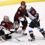 Arizona Coyotes goalie Antti Raanta (32) makes a save on a shot as Colorado Avalanche left wing Matt Nieto (83) and Coyotes defenseman Jakob Chychrun (6) vie for position during the first period of an NHL hockey game, Saturday, Dec. 23, 2017, in Glendale, Ariz. (AP Photo/Ross D. Franklin)