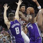 Phoenix Suns forward Marquese Chriss (0) drives to the basket against Sacramento Kings guard Bogdan Bogdanovic (8) and forward Skal Labissiere (7) during the second half of an NBA basketball game in Sacramento, Calif., Friday, Dec. 29, 2017. The Suns won 111-101. (AP Photo/Steve Yeater)