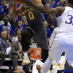 Arizona State guard Tra Holder (0) drives to the basket past Kansas guard Devonte' Graham, bottom, and center Udoka Azubuike, right, during the second half of an NCAA college basketball game in Lawrence, Kan., Sunday, Dec. 10, 2017. Arizona State defeated Kansas 95-85. (AP Photo/Orlin Wagner)