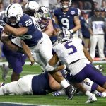 Penn State running back Saquon Barkley (26) scores a touchdown as Washington defensive back Myles Bryant (5) defends during the first half of the Fiesta Bowl NCAA college football game, Saturday, Dec. 30, 2017, in Glendale, Ariz. (AP Photo/Ross D. Franklin)