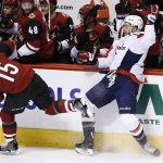 Washington Capitals right wing Tom Wilson, right, gets checked into the boards by Arizona Coyotes center Brad Richardson (15) during the first period of an NHL hockey game, Friday, Dec. 22, 2017, in Glendale, Ariz. (AP Photo/Ross D. Franklin)