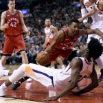 Toronto Raptors forward Norman Powell (24) commits an offensive foul against Phoenix Suns forward Josh Jackson (20) during the second half of an NBA basketball game Tuesday, Dec. 5, 2017, in Toronto. (Nathan Denette/The Canadian Press via AP)