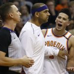 Phoenix Suns guard Devin Booker, right, is held back by teammate Jared Dudley, middle, as Booker argues his final foul with referee Justin Van Duyne, left, during the second half of an NBA basketball game against the Memphis Grizzlies, Tuesday, Dec. 26, 2017, in Phoenix. The Suns defeated the Grizzlies 99-97. (AP Photo/Ross D. Franklin)