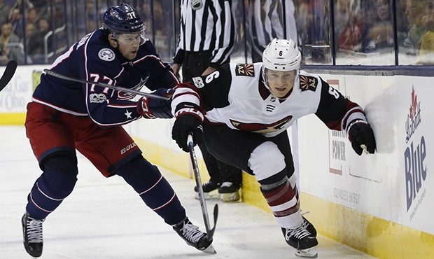 Arizona Coyotes' Jakob Chychrun, right, and Columbus Blue Jackets' Josh Anderson chase the puck dur...