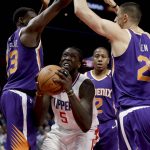 Los Angeles Clippers forward Montrezl Harrell, middle, drives to the basket past Phoenix Suns forward Danuel House Jr., left, and center Alex Len during the second half of an NBA basketball game in Los Angeles, Wednesday, Dec. 20, 2017. The Clippers won 108-95. (AP Photo/Chris Carlson)