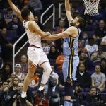 Phoenix Suns guard Devin Booker, left, tries to get off a shot over Memphis Grizzlies center Marc Gasol, right, during the second half of an NBA basketball game, Tuesday, Dec. 26, 2017, in Phoenix. The Suns defeated the Grizzlies 99-97. (AP Photo/Ross D. Franklin)