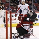 Washington Capitals right wing T.J. Oshie, top, looks at the puck after scoring a goal against Arizona Coyotes goalie Scott Wedgewood (31) during the second period of an NHL hockey game, Friday, Dec. 22, 2017, in Glendale, Ariz. The Coyotes defeated the Capitals 3-2 in overtime. (AP Photo/Ross D. Franklin)