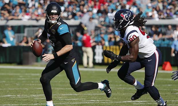 Jacksonville Jaguars quarterback Blake Bortles, left, looks for a receiver as he is pressured by Ho...
