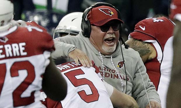 Arizona Cardinals head coach Bruce Arians is hugged by quarterback Drew Stanton (5) after Seattle S...