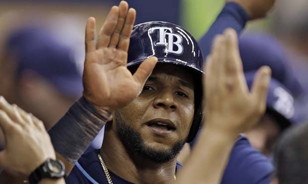 Tampa Bay Rays' Cesar Puello high-fives teammates in the dugout after scoring on a squeeze bunt by ...