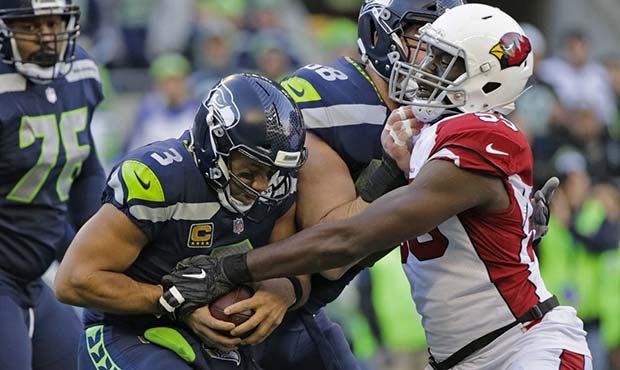 Seattle Seahawks quarterback Russell Wilson (3) protects the football as he is sacked by Arizona Ca...