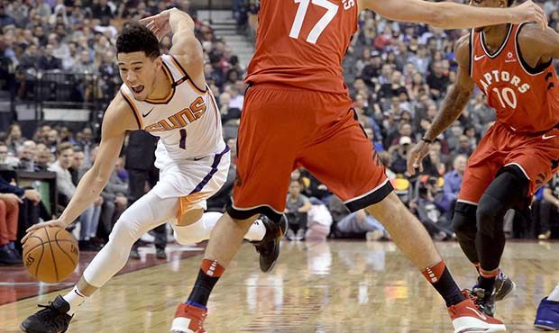 Phoenix Suns guard Devin Booker (1) moves the ball around Toronto Raptors' Joan Valanciunas during ...