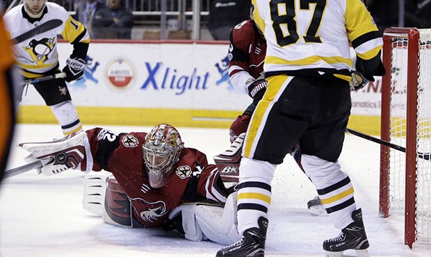 Arizona Coyotes goalie Antti Raanta (32) makes the save in front of Pittsburgh Penguins center Sidn...