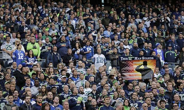 A military-themed sign that reads "This 12th Man Stands" is displayed in the stands at CenturyLink ...