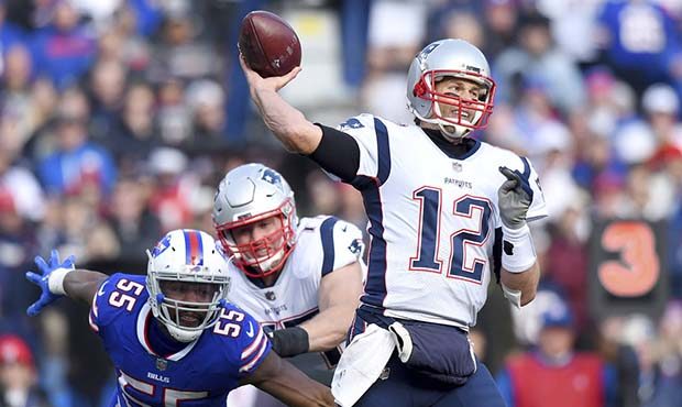 New England Patriots quarterback Tom Brady (12) throws a pass as Buffalo Bills defensive end Jerry ...