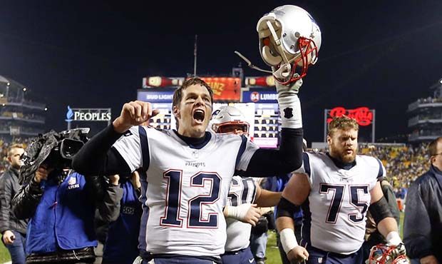 New England Patriots quarterback Tom Brady (12) celebrates with center Ted Karras (75) as they leav...