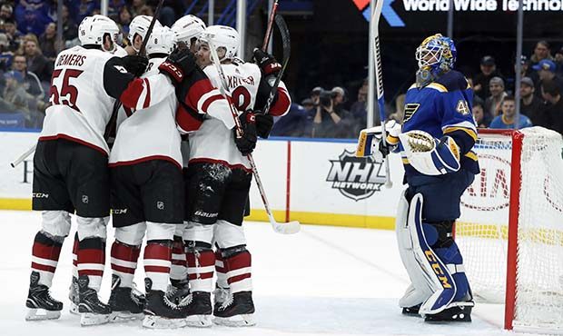 Arizona Coyotes' Christian Dvorak is surrounded by teammates after scoring past St. Louis Blues goa...