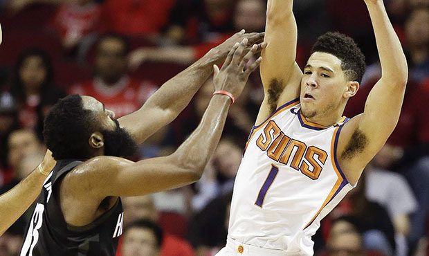 Phoenix Suns guard Devin Booker (1) passes the ball over Houston Rockets guard James Harden during ...