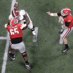 Georgia's Jake Fromm throws a ball that is deflected off the helmet of Alabama's Da'Shawn Hand and intercepted by Raekwon Davis during the second half of the NCAA college football playoff championship game Monday, Jan. 8, 2018, in Atlanta. (AP Photo/John Bazemore)