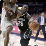 Colorado guard McKinley Wright IV (25) gets fouled by Arizona guard Allonzo Trier in the first half during an NCAA college basketball game, Thursday, Jan. 25, 2018, in Tucson, Ariz. (AP Photo/Rick Scuteri)