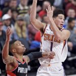 Phoenix Suns guard Devin Booker, right, passes the ball away from Portland Trail Blazers guard Damian Lillard during the second half of an NBA basketball game in Portland, Ore., Tuesday, Jan. 16, 2018. (AP Photo/Craig Mitchelldyer)