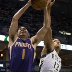 Phoenix Suns guard Devin Booker, left, is defended by Milwaukee Bucks guard Malcolm Brogdon, right, during the second half of an NBA basketball game Monday, Jan. 22, 2018, in Milwaukee. (AP Photo/Darren Hauck)