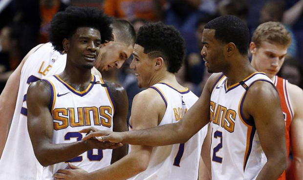 Phoenix Suns forward Josh Jackson, left, smiles as he slaps hands with Suns' Devin Booker, middle, ...