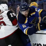 St. Louis Blues' Joel Edmundson (6) is checked into the boards by Arizona Coyotes' Nick Cousins (25) during the third period of an NHL hockey game Saturday, Jan. 20, 2018, in St. Louis. (AP Photo/Jeff Roberson)