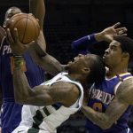 Milwaukee Bucks guard Eric Bledsoe, center, is defended by Phoenix Suns center Greg Monroe, left, and Tyler Ulis, right, during the first half of an NBA basketball game Monday, Jan. 22, 2018, in Milwaukee. (AP Photo/Darren Hauck)