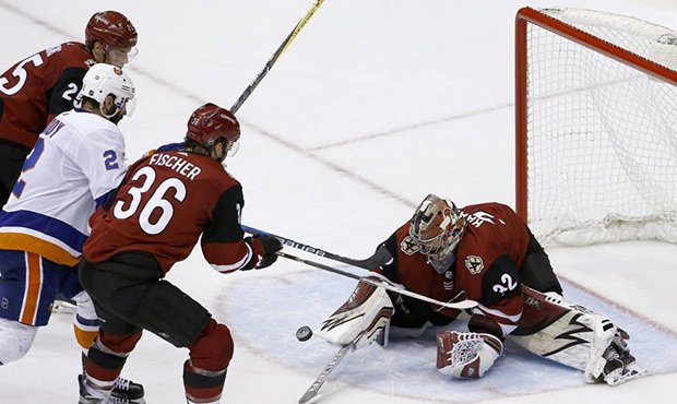 Arizona Coyotes goaltender Antti Raanta (32) dives to make a save as he gets defensive help from Co...