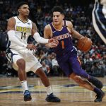 Phoenix Suns guard Devin Booker, right, drives against Denver Nuggets guard Gary Harris during the second half of an NBA basketball game Wednesday, Jan. 3, 2018, in Denver. The Nuggets won 134-111. (AP Photo/David Zalubowski)