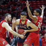 Utah's David Collette, left and Gabe Bealer (30) defend against Arizona center Dusan Ristic, center, in the first half during an NCAA college basketball game Thursday, Jan. 4, 2018, in Salt Lake City. (AP Photo/Rick Bowmer)