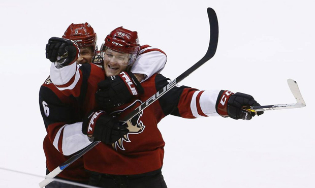 Arizona Coyotes right wing Christian Fischer (36) and Coyotes defenseman Jakob Chychrun (6) celebra...