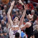 Phoenix Suns forward Dragan Bender, left, has a shot blocked by Portland Trail Blazers center Jusuf Nurkic during the second half of an NBA basketball game in Portland, Ore., Tuesday, Jan. 16, 2018. (AP Photo/Craig Mitchelldyer)