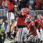 Georgia's Kendall Baker lifts quarterback Jake Fromm (11) after a long touchdown pass during the second half of the NCAA college football playoff championship game against Alabama Monday, Jan. 8, 2018, in Atlanta. (AP Photo/David J. Phillip)