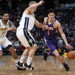Phoenix Suns guard Devin Booker, right, drives past Denver Nuggets center Mason Plumlee, center, and forward Wilson Chandler during the second half of an NBA basketball game Wednesday, Jan. 3, 2018, in Denver. The Nuggets won 134-111. (AP Photo/David Zalubowski)