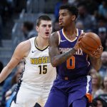 Phoenix Suns forward Marquese Chriss, front, looks to pass the ball as Denver Nuggets center Nikola Jokic, of Serbia, defends in the first half of an NBA basketball game Wednesday, Jan. 3, 2018, in Denver. (AP Photo/David Zalubowski)