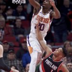Phoenix Suns forward Josh Jackson, left, dunks over Portland Trail Blazers guard Evan Turner during the first half of an NBA basketball game in Portland, Ore., Tuesday, Jan. 16, 2018. (AP Photo/Craig Mitchelldyer)