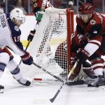 Columbus Blue Jackets right wing Cam Atkinson (13) passes the puck past Arizona Coyotes defenseman Niklas Hjalmarsson (4) during the first period of an NHL hockey game, Thursday, Jan. 25, 2018, in Glendale, Ariz. (AP Photo/Ross D. Franklin)