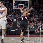 Portland Trail Blazers guard CJ McCollum, right, reacts after making a three point basket over Phoenix Suns forward Dragan Bender during the first half of an NBA basketball game in Portland, Ore., Tuesday, Jan. 16, 2018. (AP Photo/Craig Mitchelldyer)
