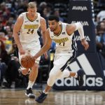 Denver Nuggets guard Jamal Murray, front, picks up a loose ball in front of center Mason Plumlee in the first half of an NBA basketball game against the Phoenix Suns Wednesday, Jan. 3, 2018, in Denver. (AP Photo/David Zalubowski)