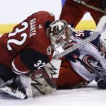 Arizona Coyotes goaltender Antti Raanta (32) makes a save as he collides with Columbus Blue Jackets left wing Jussi Jokinen (36) during the first period of an NHL hockey game, Thursday, Jan. 25, 2018, in Glendale, Ariz. (AP Photo/Ross D. Franklin)