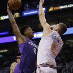 Phoenix Suns forward Marquese Chriss (0) drives against New York Knicks forward Kristaps Porzingis during the second half during an NBA basketball game Friday, Jan. 26, 2018, in Phoenix. The Knicks defeated the Suns 107-85. (AP Photo/Rick Scuteri)