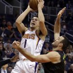 Phoenix Suns guard Devin Booker (1) drives on Atlanta Hawks guard Marco Belinelli during the second half of an NBA basketball game Tuesday, Jan. 2, 2018, in Phoenix. The Suns defeated the Hawks 104-103. (AP Photo/Rick Scuteri)