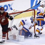 New York Islanders goaltender Jaroslav Halak (41) reaches over to make a save as Arizona Coyotes center Derek Stepan, left, trips over him while Islanders right wing Cal Clutterbuck (15) tries to help defend during the second period of an NHL hockey game, Monday, Jan. 22, 2018, in Glendale, Ariz. (AP Photo/Ross D. Franklin)